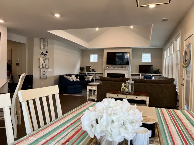 a kitchen with stainless steel appliances a dining table chairs refrigerator and microwave