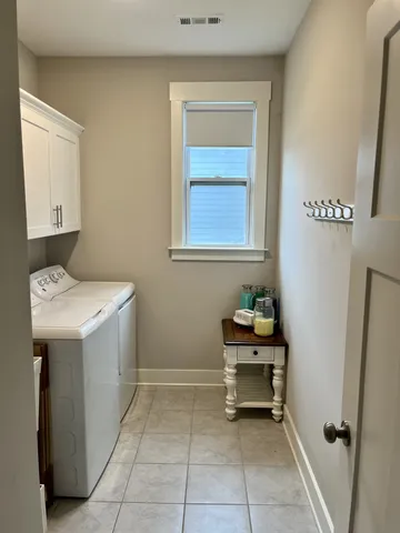 a view of a house with brick walls and a yard with plants