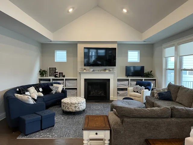 a living room with furniture a flat screen tv and a fireplace