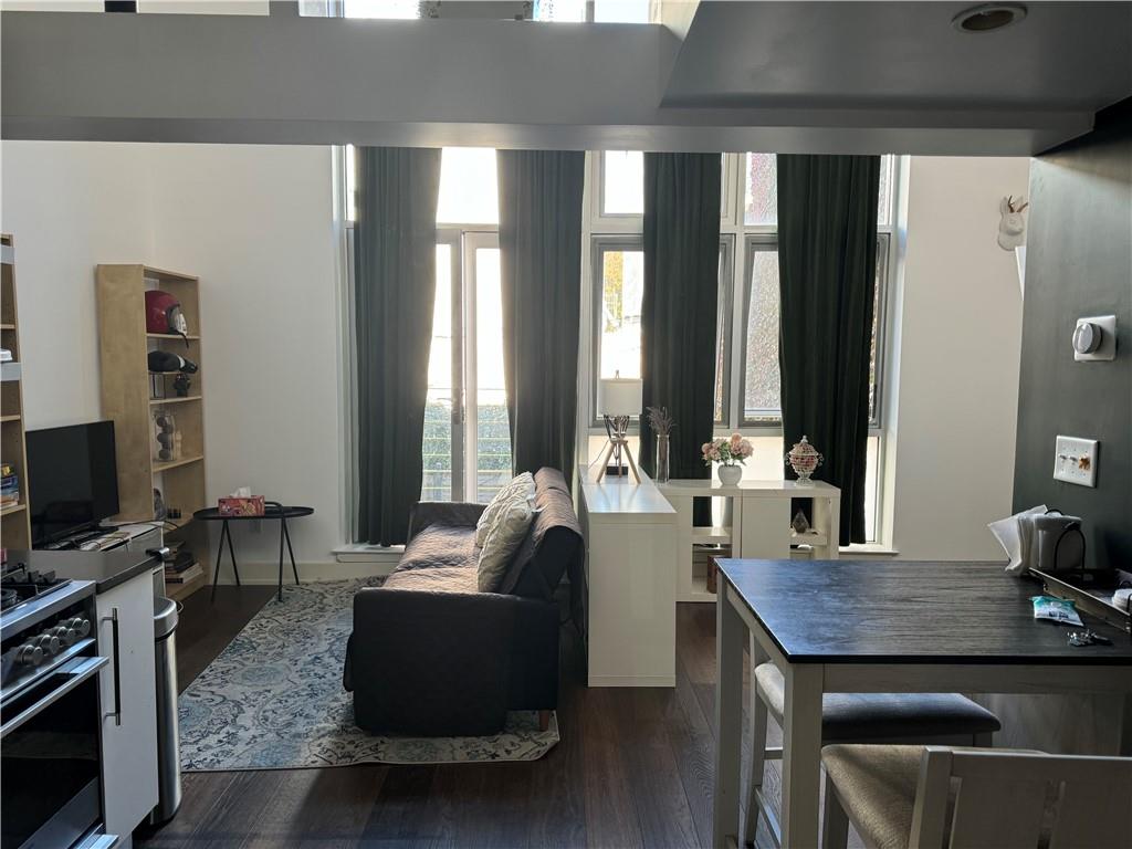 a living room with furniture a flat screen tv and large windows