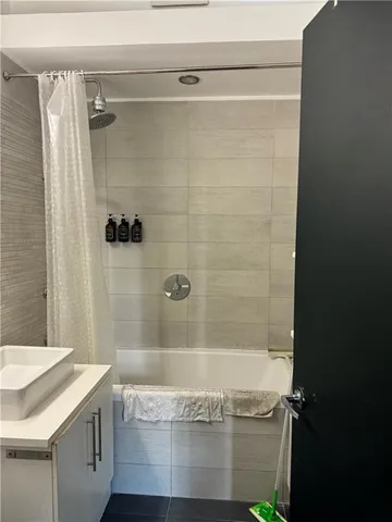 a bathroom with a granite countertop sink a toilet and shower