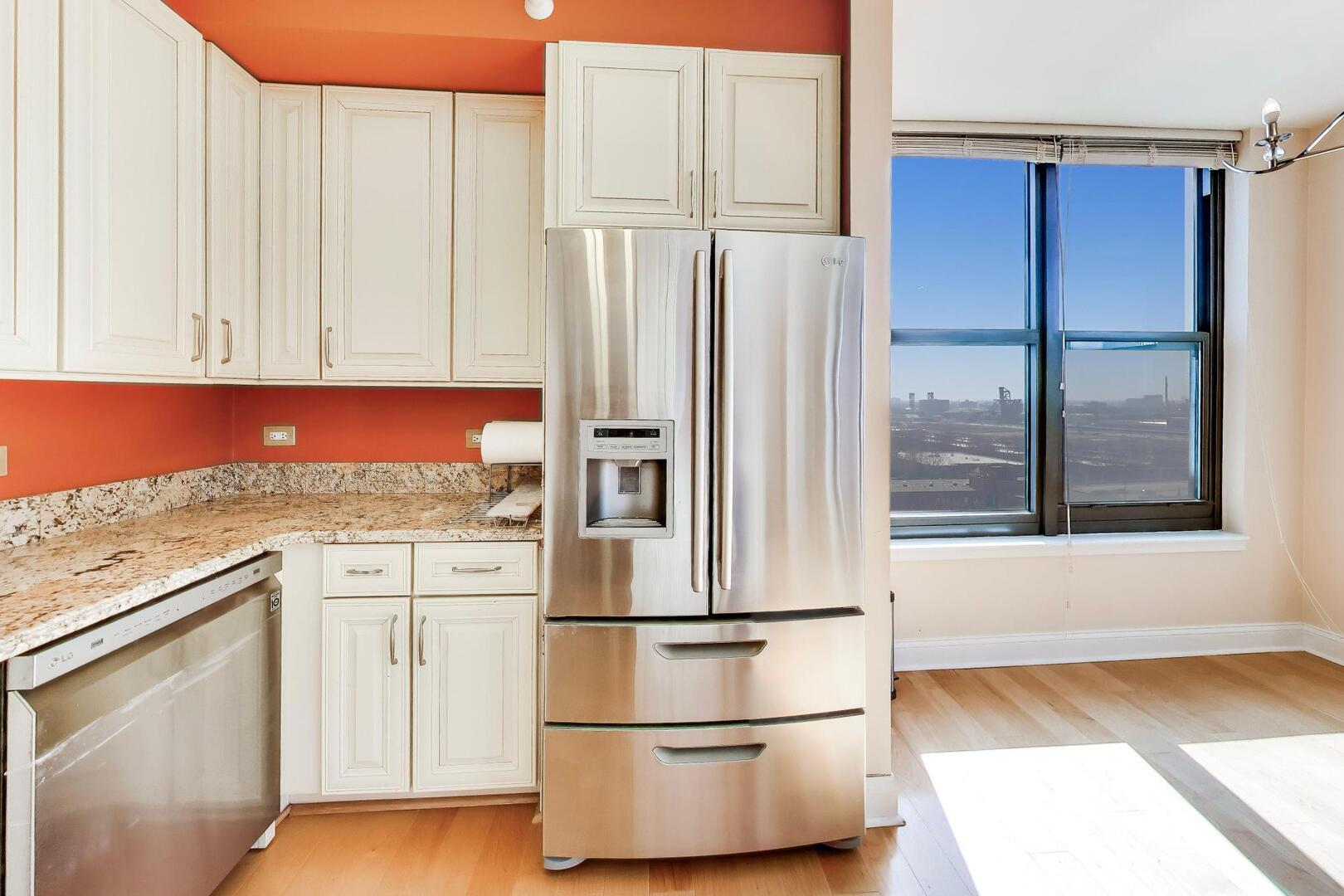 1101 South State Street, Unit 1307 Chicago, IL 60605 - Photo 12 of 31 a kitchen with stainless steel appliances granite countertop a refrigerator sink and white cabinets