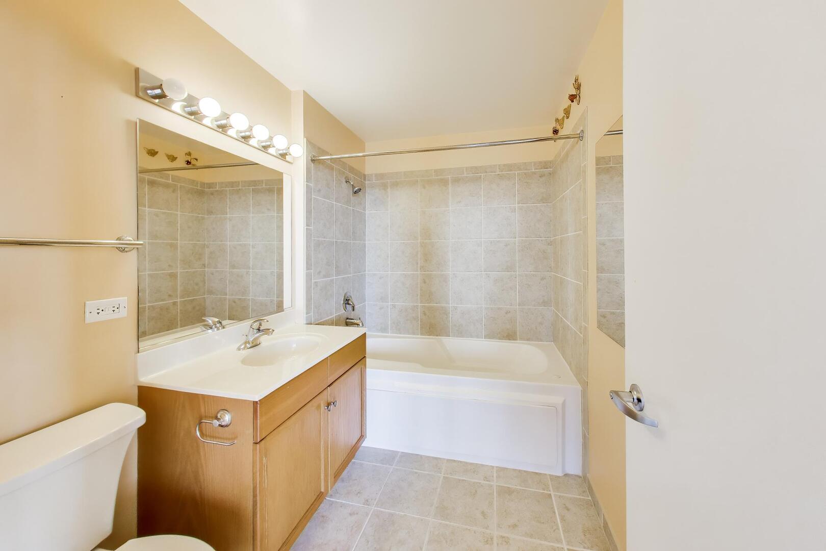 1101 South State Street, Unit 1307 Chicago, IL 60605 - Photo 23 of 31 a bathroom with a tub sink and mirror