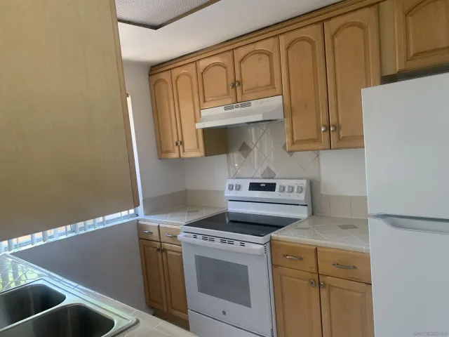 a kitchen with stainless steel appliances granite countertop a sink and a stove