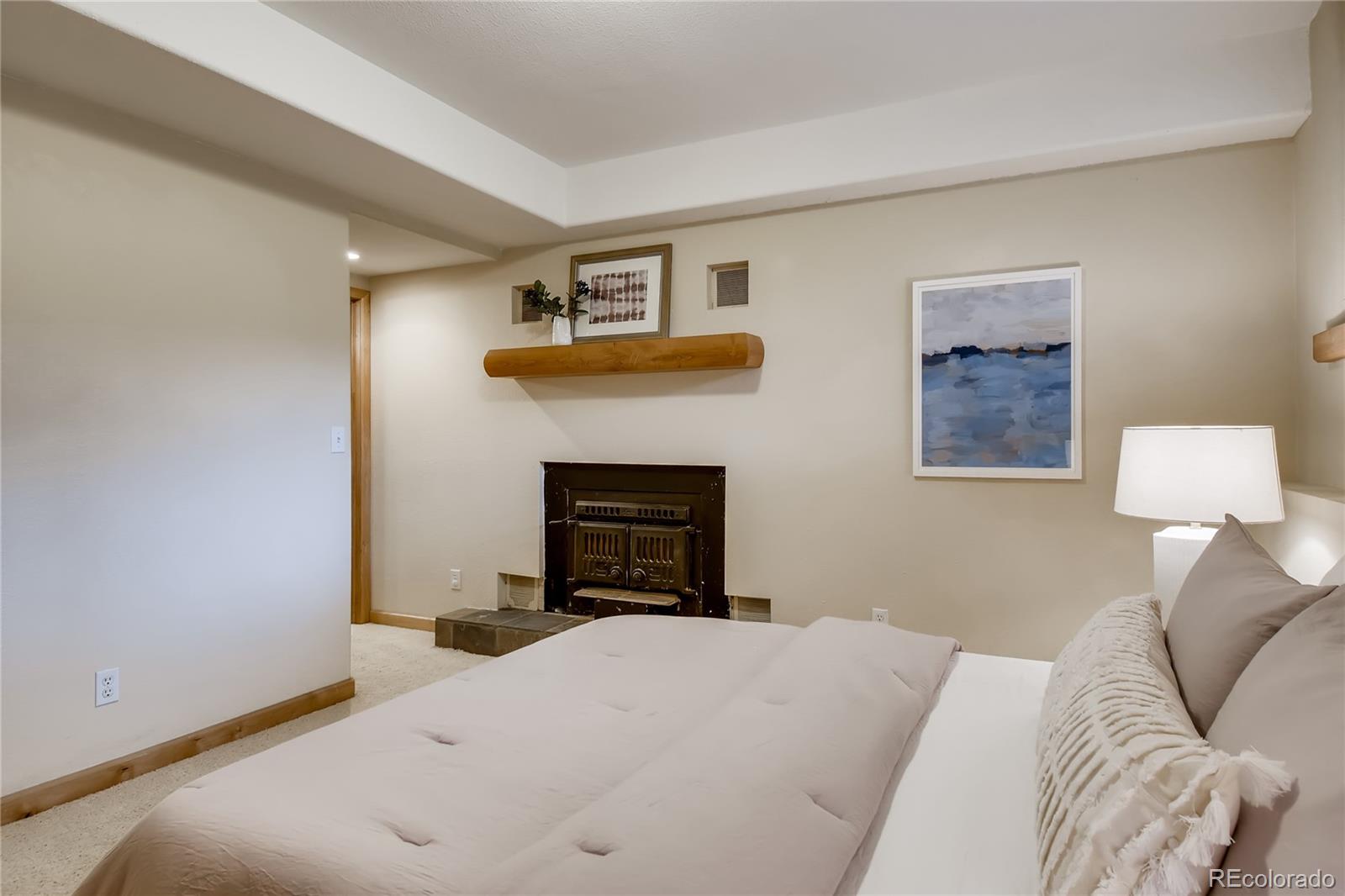 32104 Snowshoe Road Evergreen, CO 80439 - Photo 15 of 36 a bedroom with a bed and a fireplace