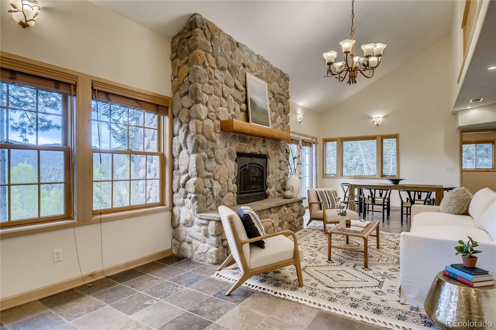32104 Snowshoe Road Evergreen, CO 80439 - Photo 2 of 36 a view of a livingroom with furniture wooden floor and chandelier