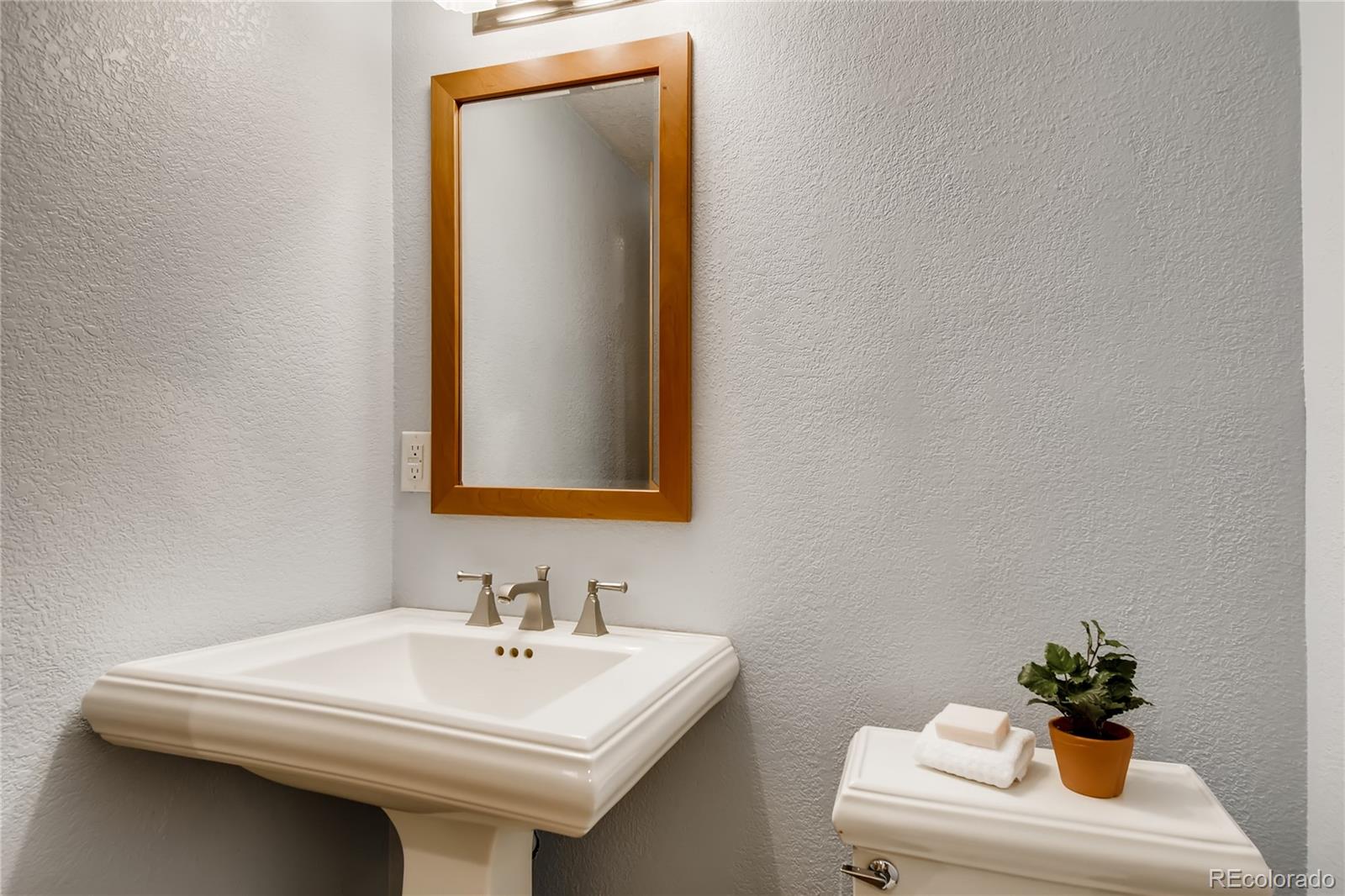 32104 Snowshoe Road Evergreen, CO 80439 - Photo 21 of 36 a bathroom with a sink a mirror and a toilet
