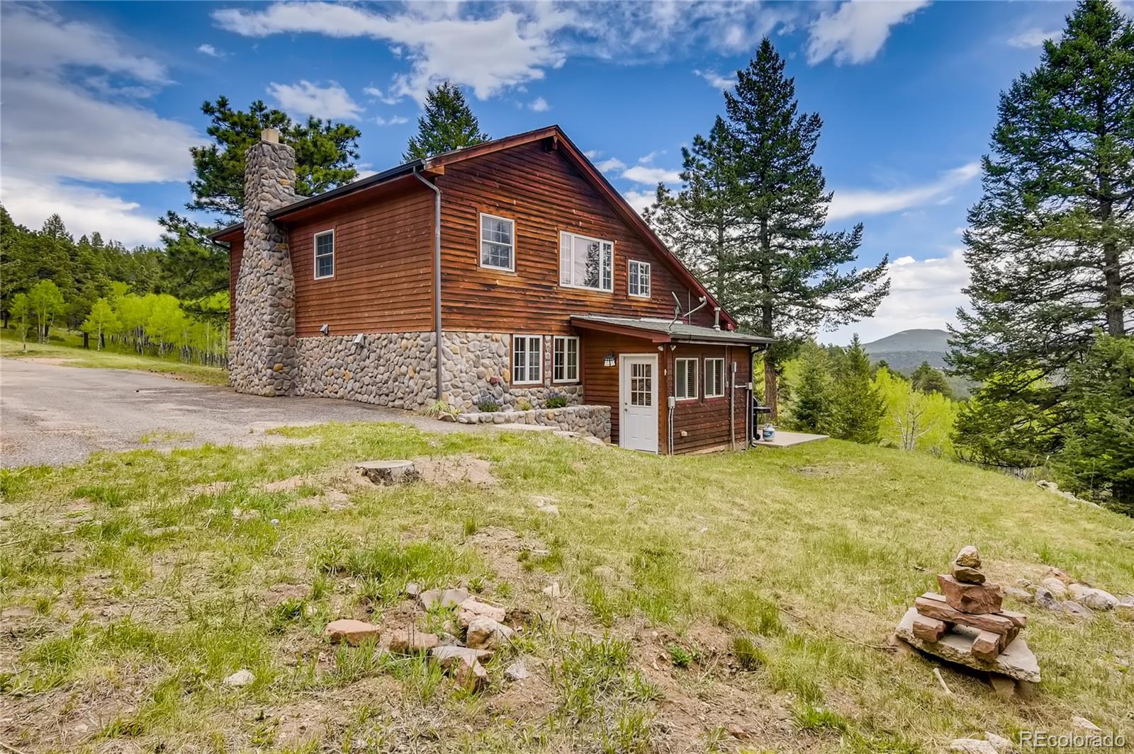 32104 Snowshoe Road Evergreen, CO 80439 - Photo 23 of 36 a view of a house with a yard and garage
