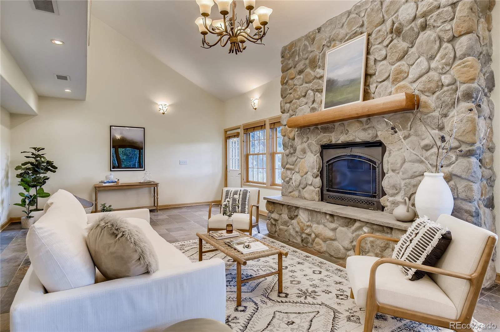 32104 Snowshoe Road Evergreen, CO 80439 - Photo 3 of 36 a living room with furniture and a fireplace