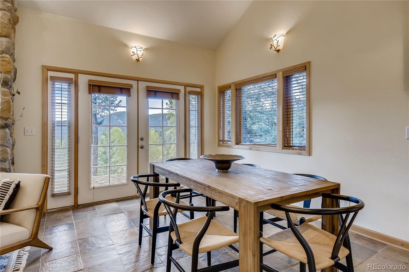32104 Snowshoe Road Evergreen, CO 80439 - Photo 4 of 36 a view of a dining room with furniture and window
