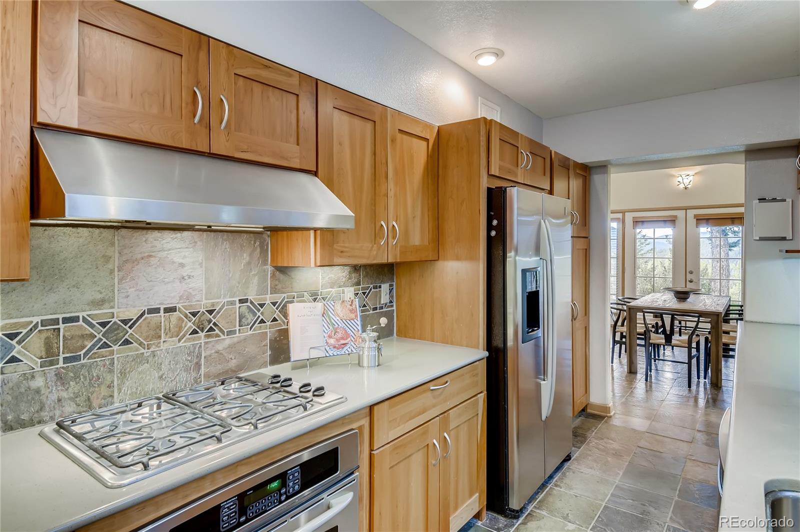 32104 Snowshoe Road Evergreen, CO 80439 - Photo 7 of 36 a kitchen with stainless steel appliances granite countertop a stove refrigerator and cabinets