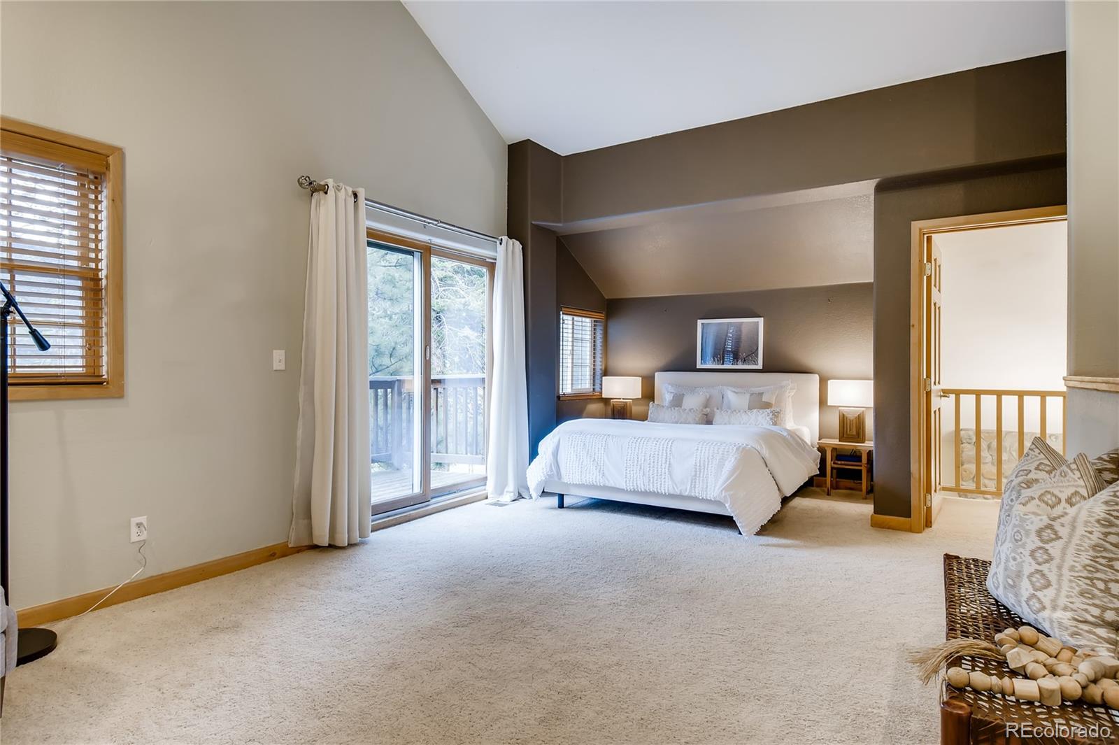 32104 Snowshoe Road Evergreen, CO 80439 - Photo 9 of 36 a spacious bedroom with a bed and a window