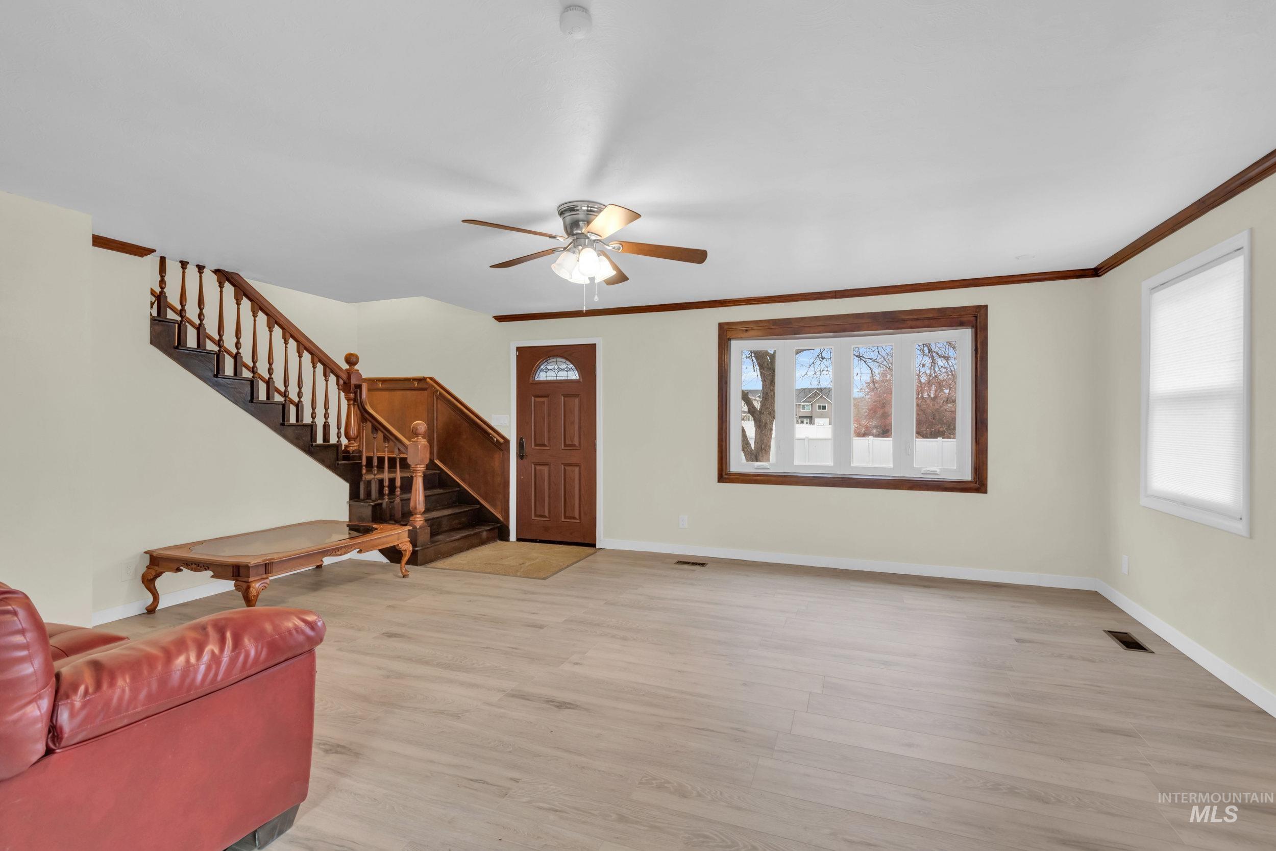 1158 South Powerline Road Nampa, ID 83686 - Photo 14 of 50 Living room with stairs, light wood finished floors, and a ceiling fan