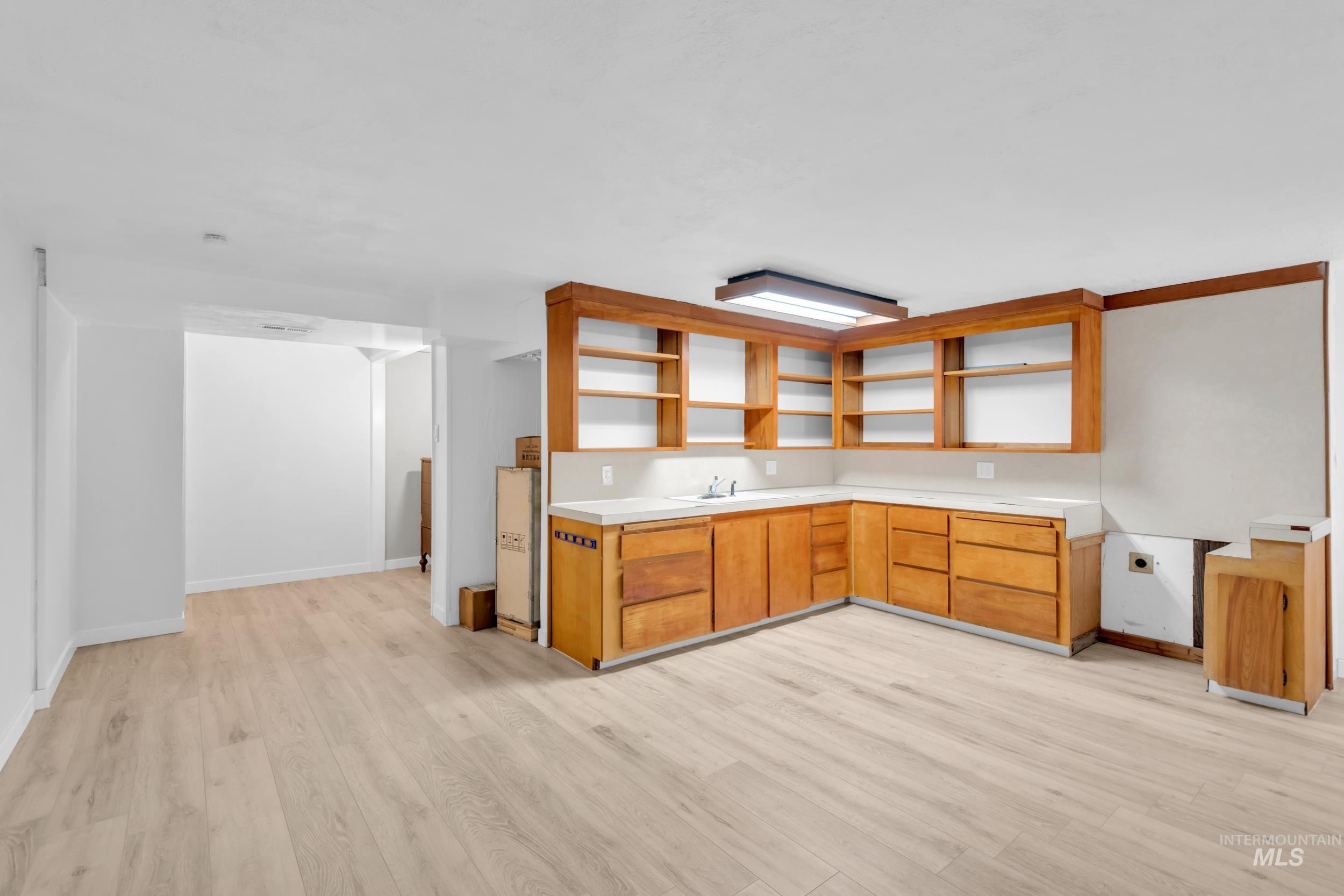 1158 South Powerline Road Nampa, ID 83686 - Photo 26 of 50 Kitchen with open shelves, brown cabinets, light countertops, and light wood finished floors