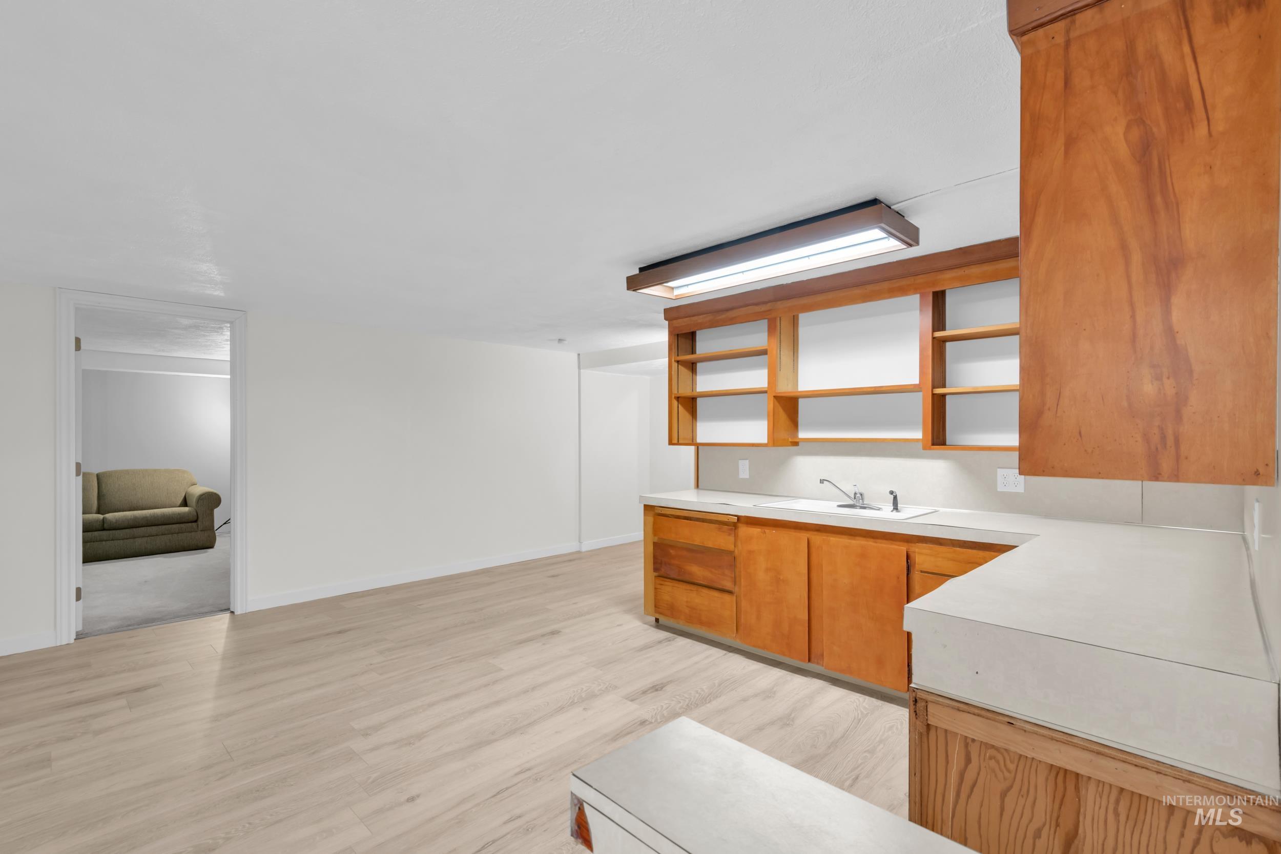1158 South Powerline Road Nampa, ID 83686 - Photo 27 of 50 Kitchen with open shelves, light countertops, brown cabinets, and light wood-style flooring