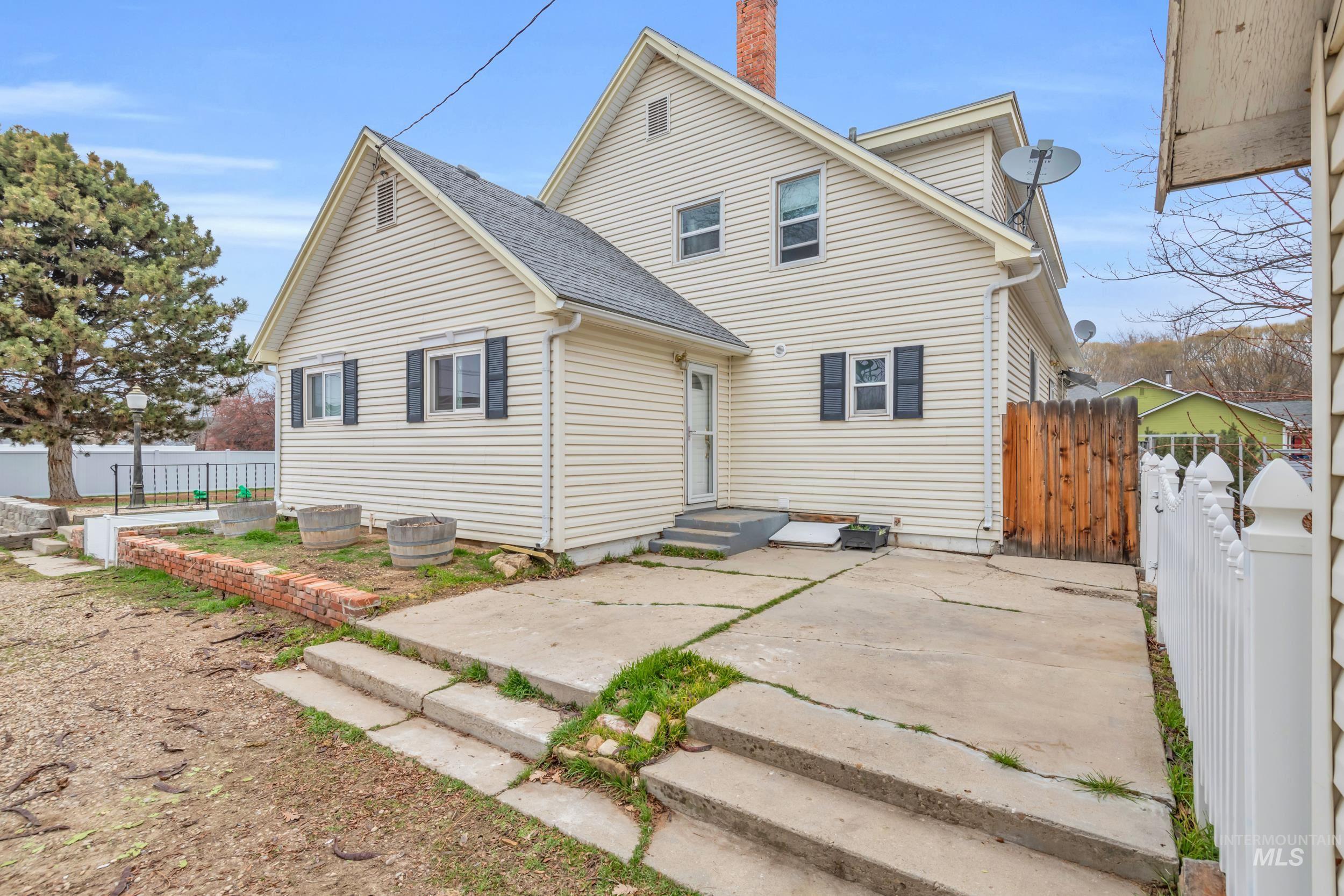 1158 South Powerline Road Nampa, ID 83686 - Photo 42 of 50 Rear view of property featuring roof with shingles, a chimney, and a patio