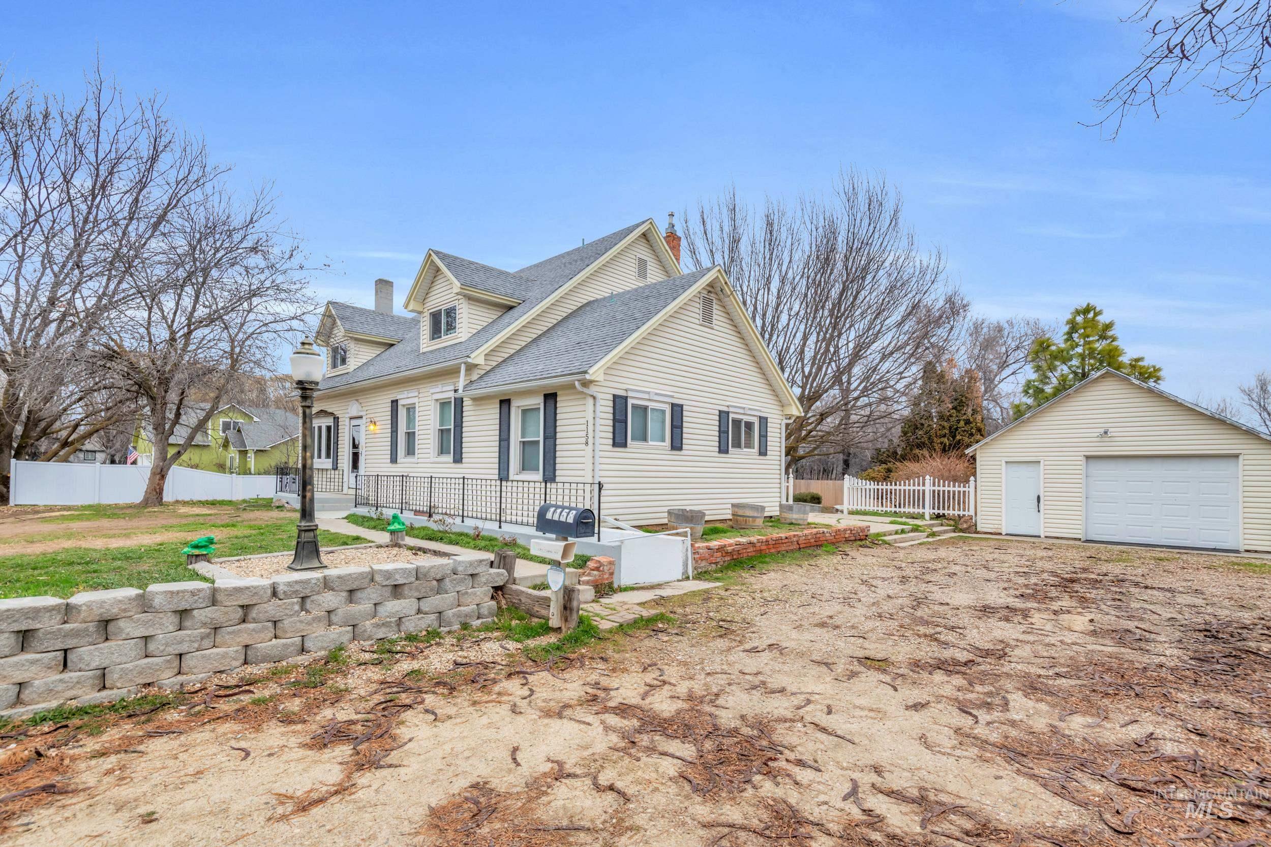 1158 South Powerline Road Nampa, ID 83686 - Photo 43 of 50 View of side of property featuring a garage, an outbuilding, a chimney, and a shingled roof