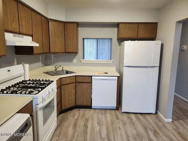 a kitchen with a refrigerator sink stove and cabinets