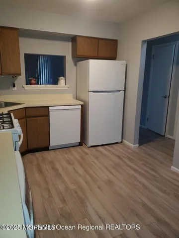 a kitchen with a refrigerator and a stove top oven