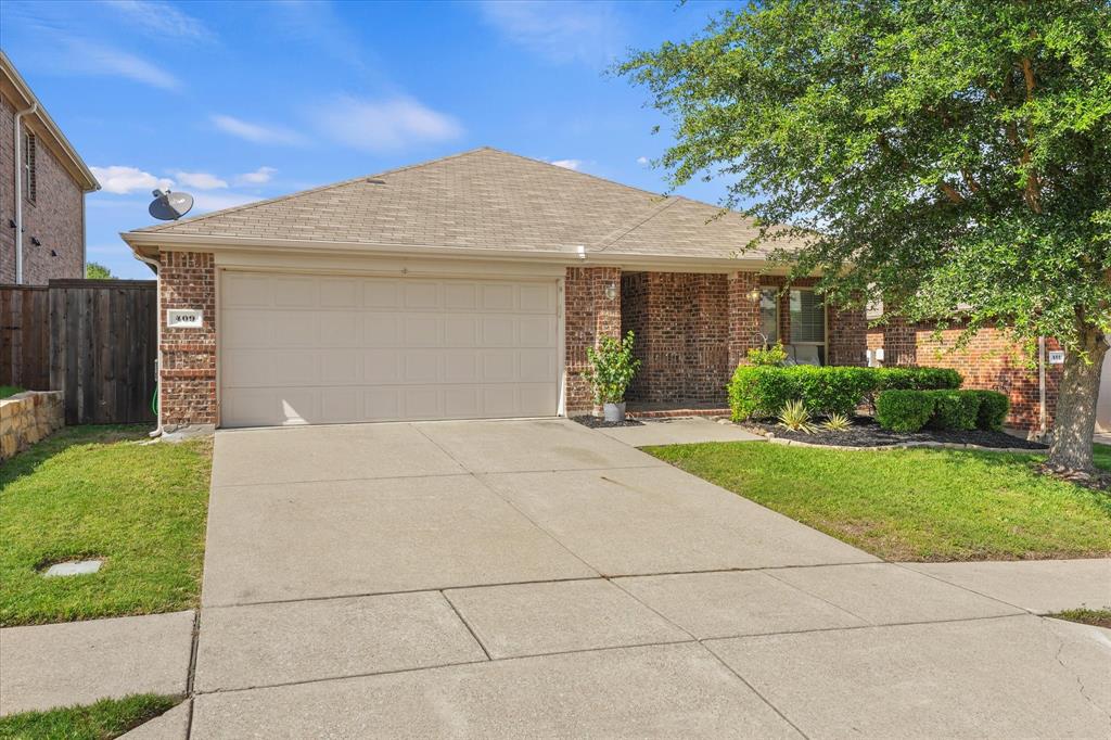 409 Harding Lane Lavon, TX 75166 - Photo 1 of 34 Brick exterior with a beige garage door, concrete driveway, and a shingled roof