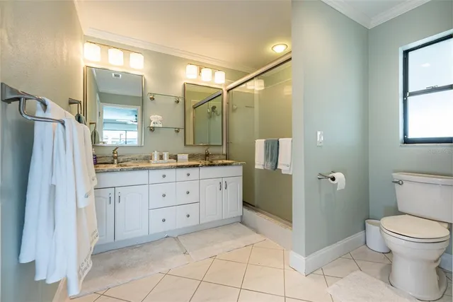 a spacious bathroom with a granite countertop sink toilet and shower