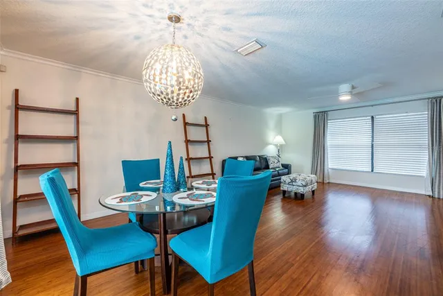 a dining room with furniture a chandelier and wooden floor