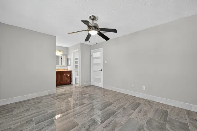 a view of an empty room with a ceiling fan