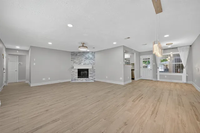 a view of empty room with wooden floor and fireplace