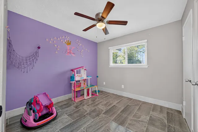 a view of a livingroom with wooden floor and a ceiling fan