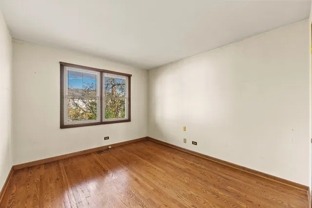 an empty room with a window and painting on a wall