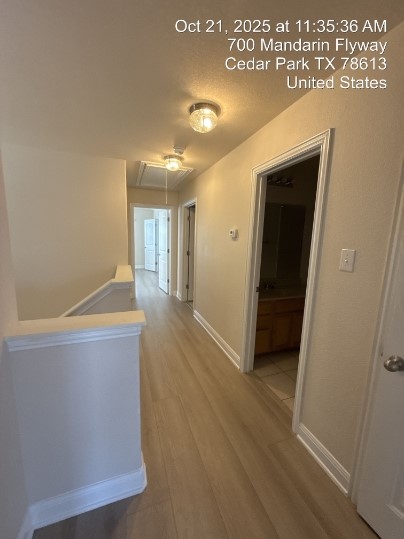 700 Mandarin Flyway, Unit 1401 Cedar Park, TX 78613 - Photo 19 of 27 Hallway featuring attic access, an upstairs landing, and light wood finished floors