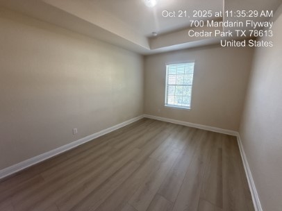 700 Mandarin Flyway, Unit 1401 Cedar Park, TX 78613 - Photo 23 of 27 Empty room with wood finished floors and a raised ceiling