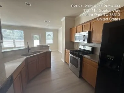 a large kitchen with stainless steel appliances granite countertop a sink a stove a refrigerator a s a counter top and a stove