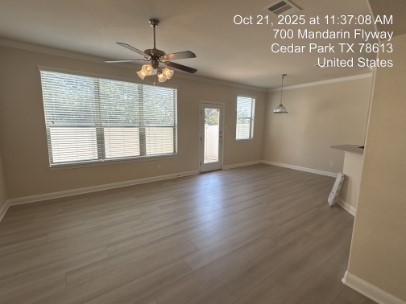 700 Mandarin Flyway, Unit 1401 Cedar Park, TX 78613 - Photo 8 of 27 Unfurnished living room featuring crown molding, dark wood finished floors, and a ceiling fan