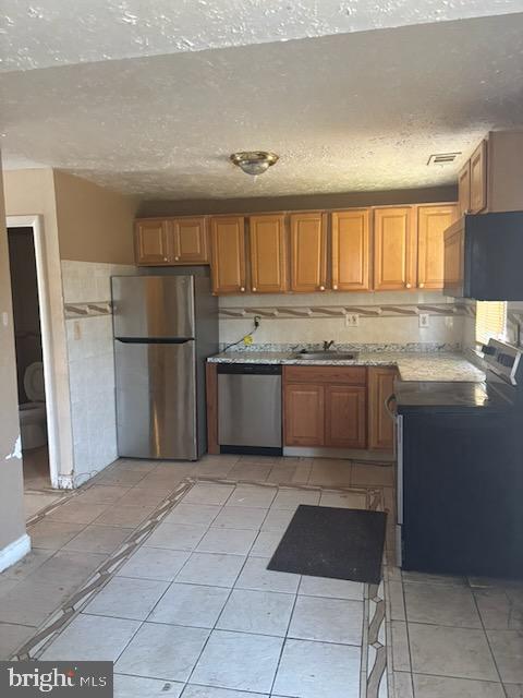 5104 Emo Street Capitol Heights, MD 20743 - Photo 9 of 24 a kitchen with granite countertop a refrigerator and a sink