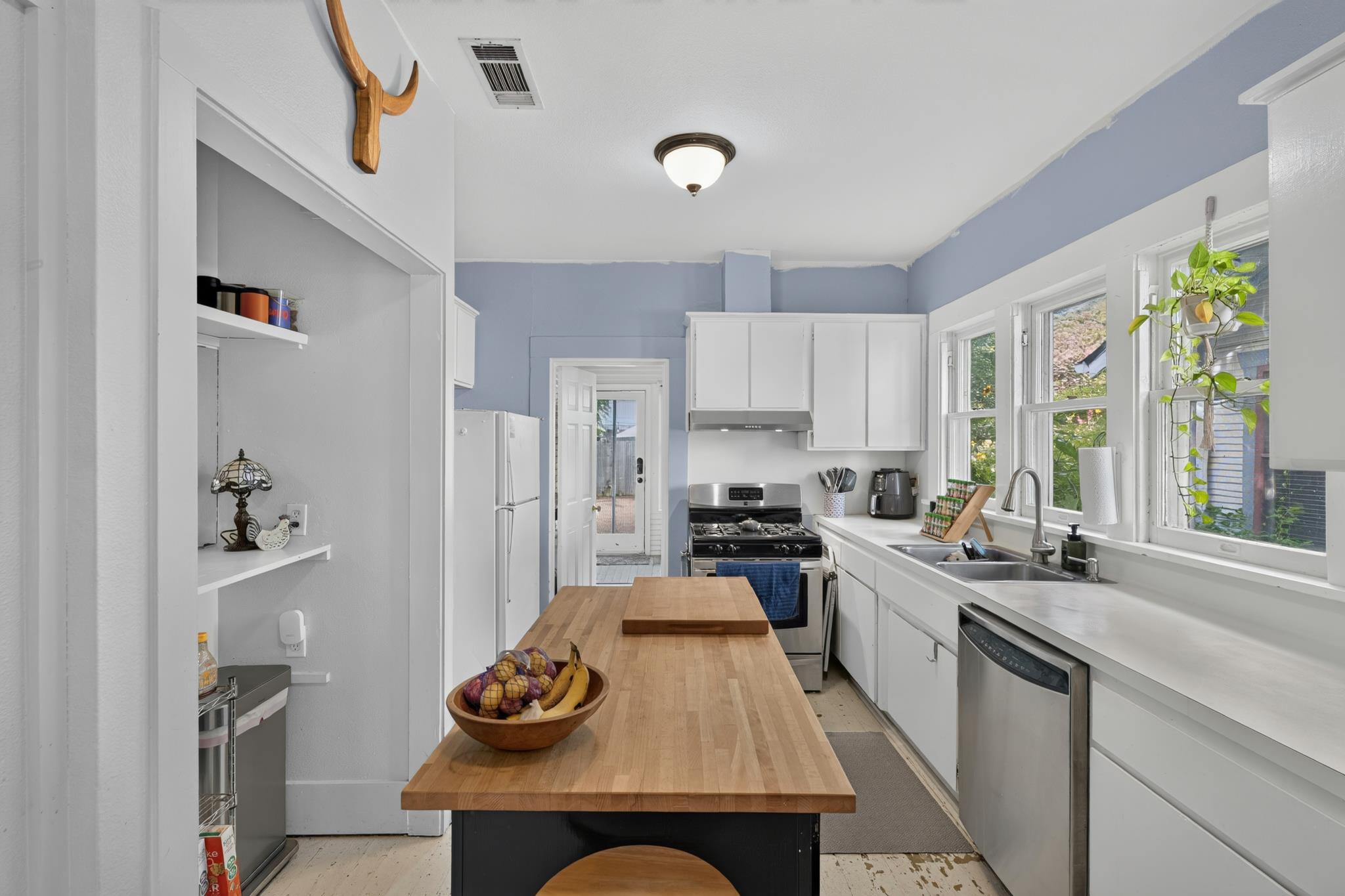 307 East 35th Street, Unit A Austin, TX 78705 - Photo 23 of 40 A galley kitchen with butcher block island, stainless steel appliances, and ample natural light.