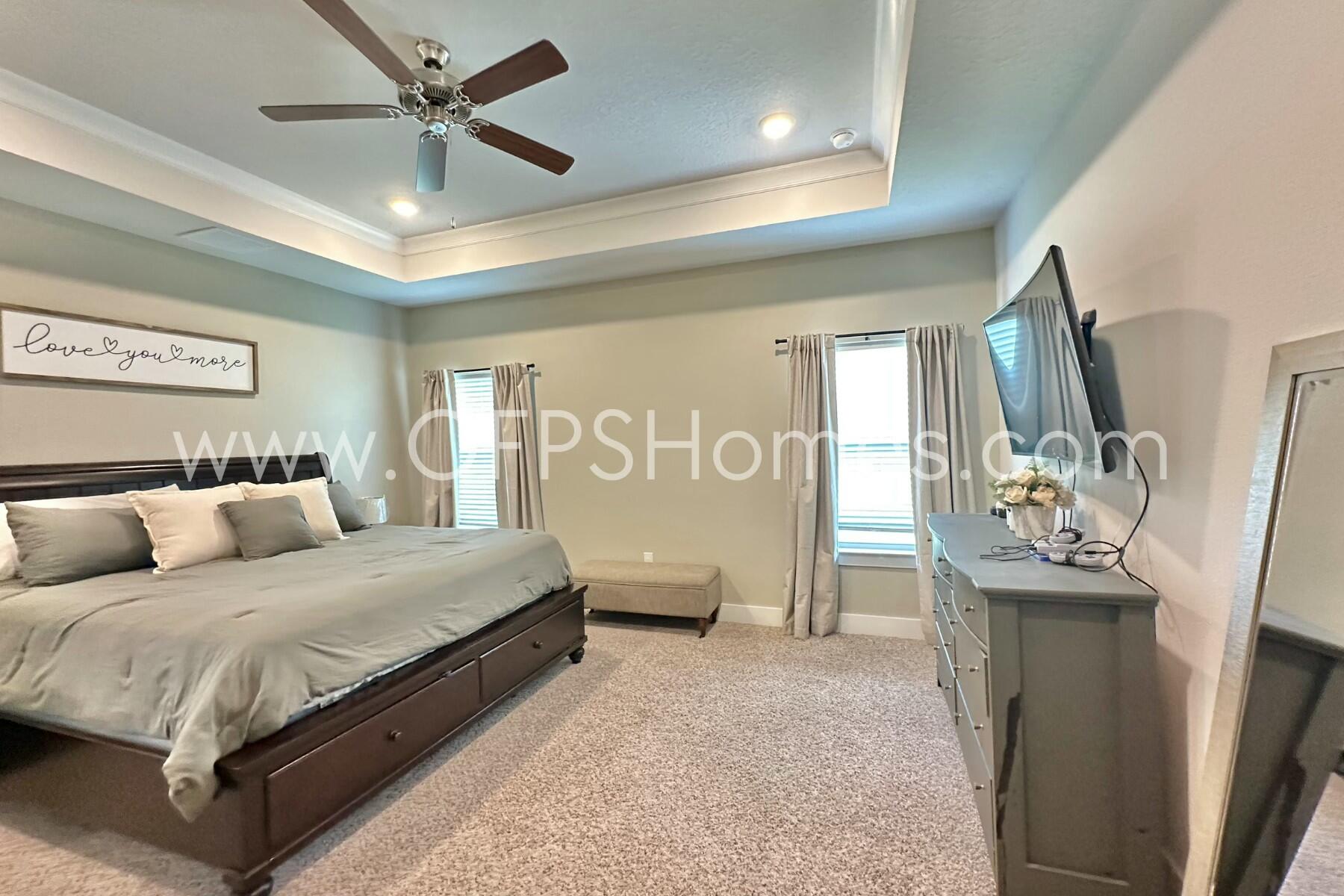 2412 Dakota Way Crestview, FL 32536 - Photo 23 of 43 a bedroom with a large bed and a chandelier