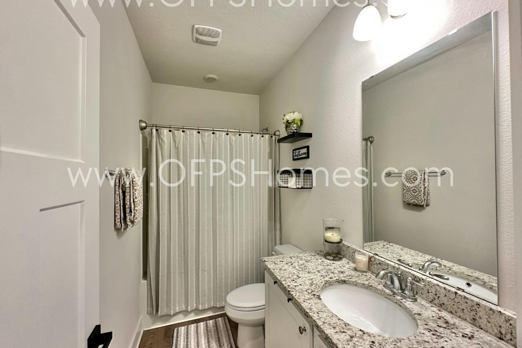 2412 Dakota Way Crestview, FL 32536 - Photo 3 of 43 a bathroom with a granite countertop sink toilet and shower