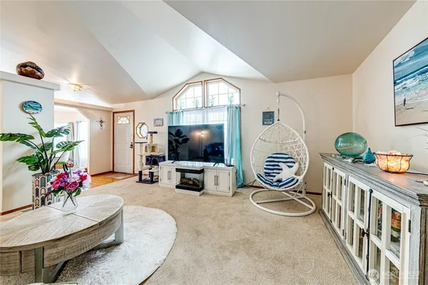 a living room with furniture a flat screen tv and a large window