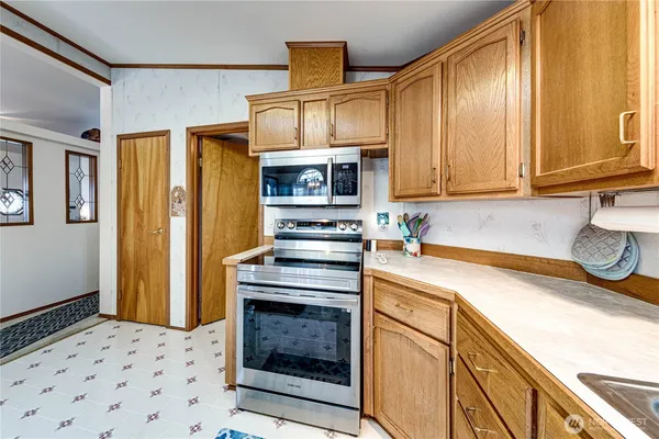 a kitchen with stainless steel appliances granite countertop a stove a sink and a refrigerator