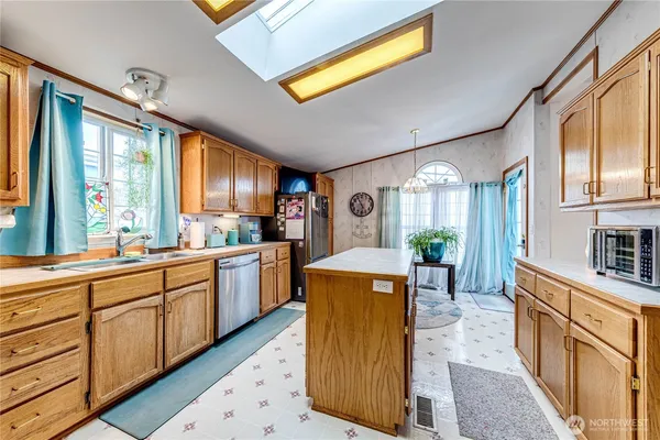 a large kitchen with stainless steel appliances granite countertop a large window a sink and cabinets
