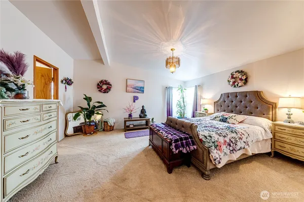 a bedroom with a bed and a chandelier