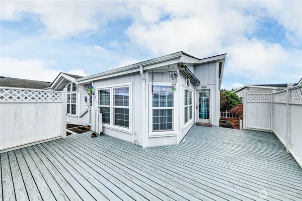 a view of a house with a barbeque and wooden stairs