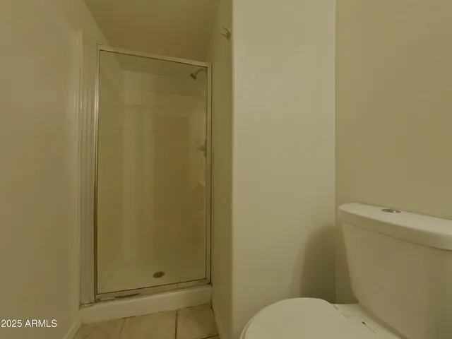 a white toilet sitting next to a shower