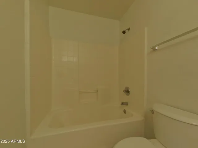 a bathroom with a granite countertop toilet and a bathtub