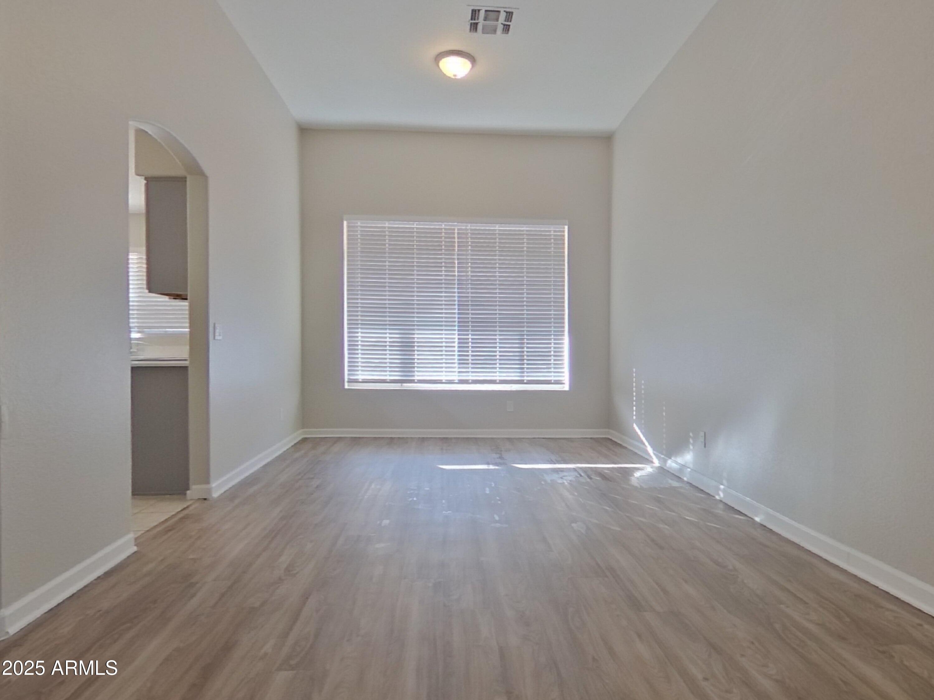 10365 West Piccadilly Road Avondale, AZ 85392 - Photo 2 of 20 an empty room with wooden floor and windows
