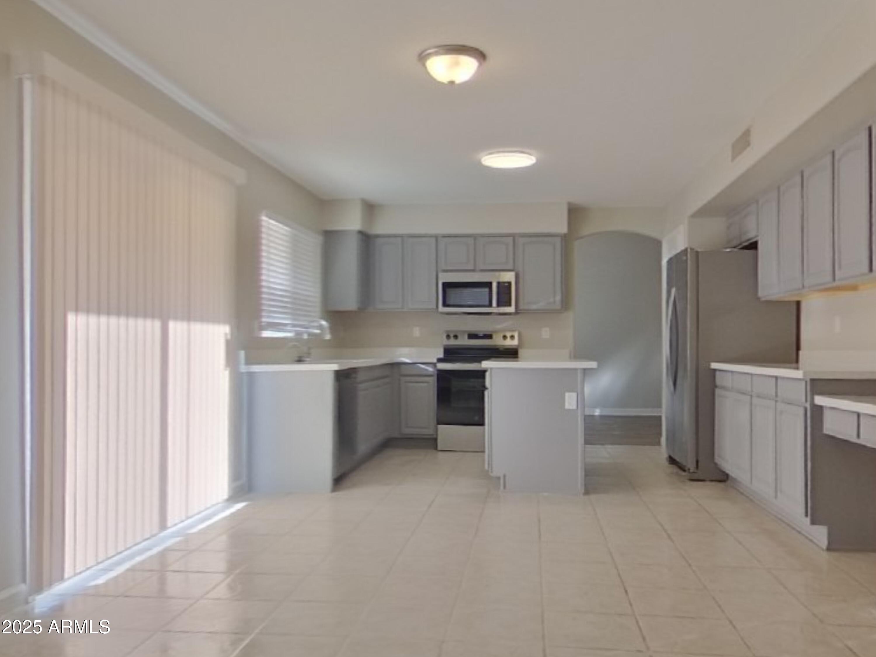 10365 West Piccadilly Road Avondale, AZ 85392 - Photo 4 of 20 a kitchen with a refrigerator and cabinets