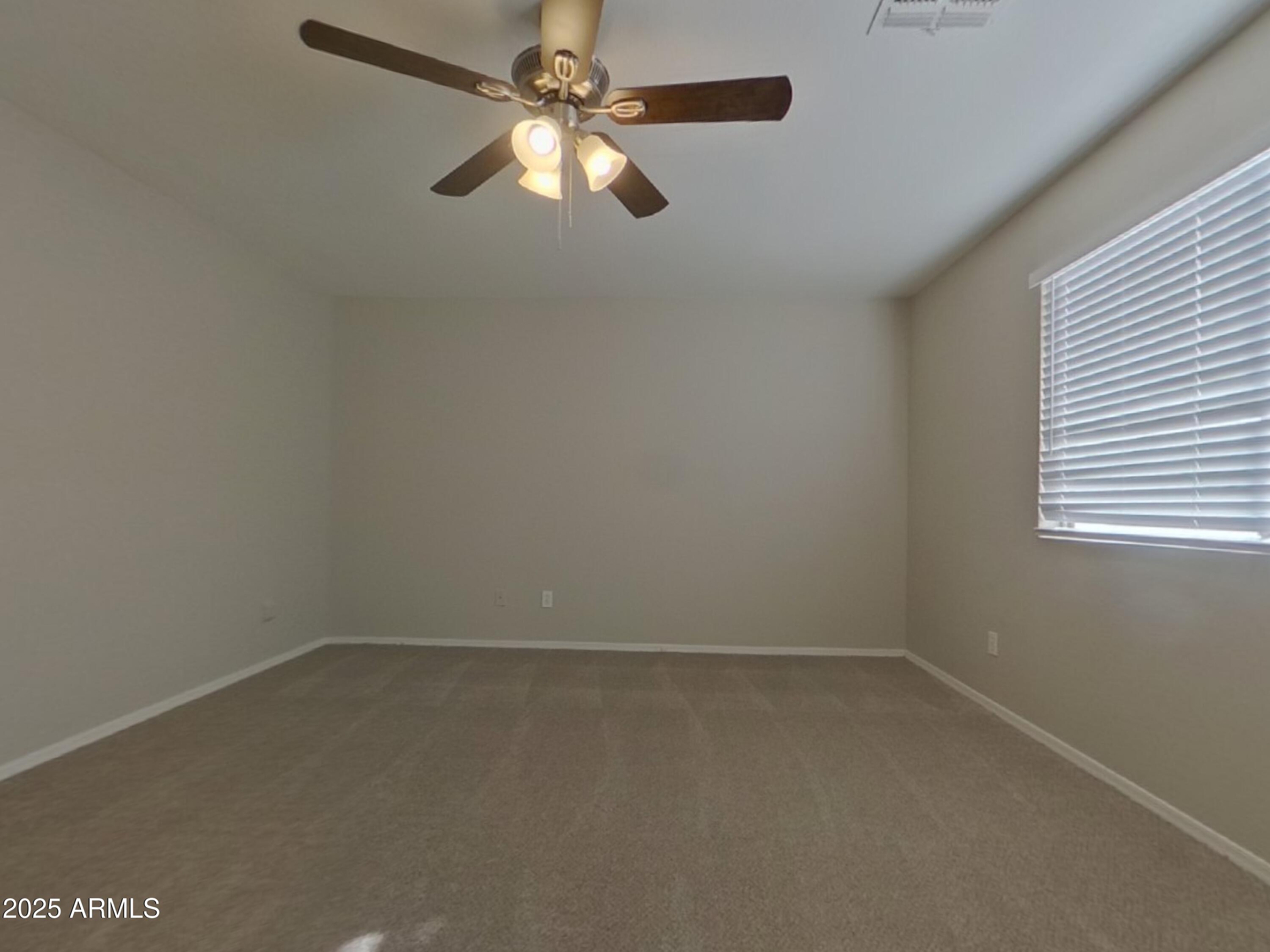 10365 West Piccadilly Road Avondale, AZ 85392 - Photo 7 of 20 an empty room with a window and a fan