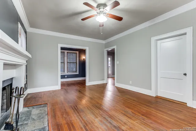 a view of an empty room with window and wooden floor
