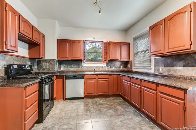 a kitchen with stainless steel appliances granite countertop wooden cabinets a sink and a stove